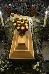 Heller Holzsarg mit einem Herz aus roten und weißen Rosen